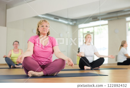 Group of mature woman making yoga meditation in lotus pose Group of mature woman making yoga meditation in lotus pose 122892432