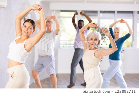 Active men and women of different ages practicing Jazz-funk dance in training hall Active men and women of different ages practicing Jazz-funk dance in training hall 122892711
