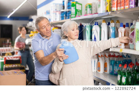MAture couple shopping in supermarket, chooses plastic bottle of household detergent 122892724