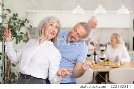 Couple of elderly man and woman dancing in kitchen Couple of elderly man and woman dancing in kitchen 122892814