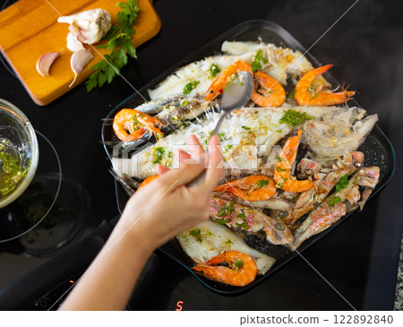 Preparation of fied seafood dish with garlic herb sauce Preparation of fied seafood dish with garlic herb sauce 122892840