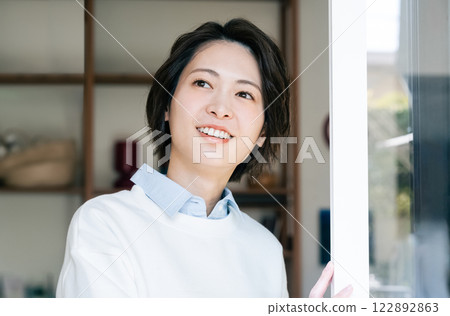 Woman looking outside from the living room 122892863