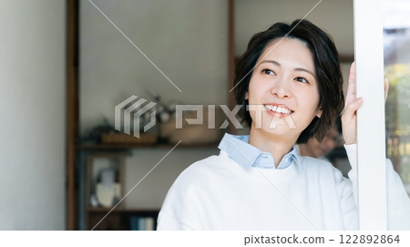 Woman looking outside from the living room 122892864