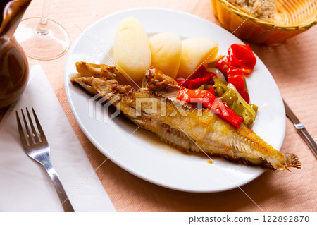 Deliciously grilled wrasse fish with peppers and potatoes served 122892870