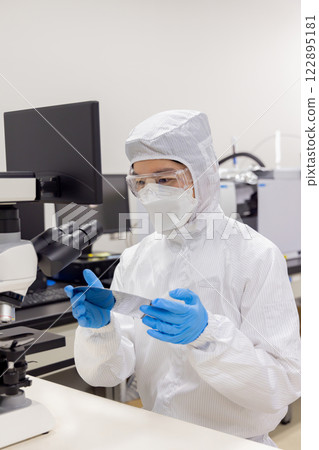 Engineer inspecting a silicon wafer Engineer inspecting a silicon wafer 122895181