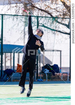 Middle men playing tennis 122895423