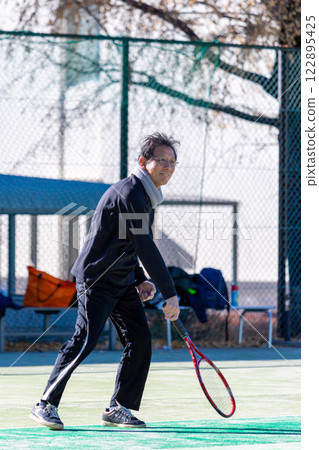 Middle men playing tennis 122895425