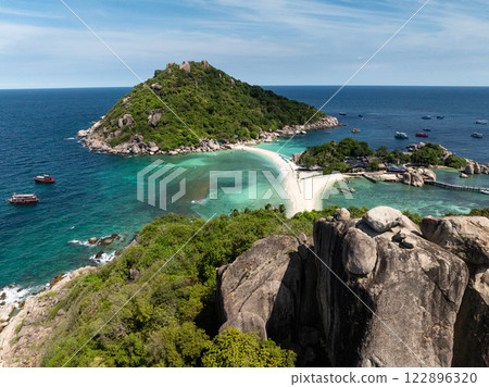 A lush tropical island with a rocky coastline surrounded by clear turquoise waters and sunny skies. Ko Nang Yuan, Thailand. 122896320