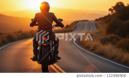 Rider enjoying a peaceful sunset along a winding road surrounded by nature Rider enjoying a peaceful sunset along a winding road surrounded by nature 122896908