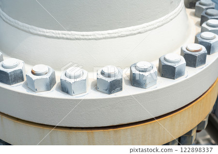 Close-up of an industrial bolted flange showcasing engineering precision and structural reliability Close-up of an industrial bolted flange showcasing engineering precision and structural reliability 122898337