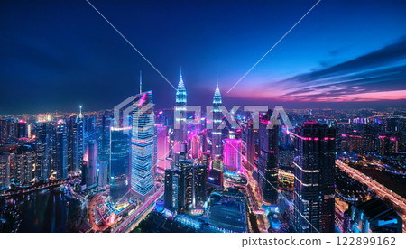 A city skyline at night with neon lights and a purple sky 122899162