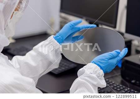Engineer inspecting a silicon wafer Engineer inspecting a silicon wafer 122899511