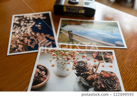 Instant camera and photos on a table 122899593
