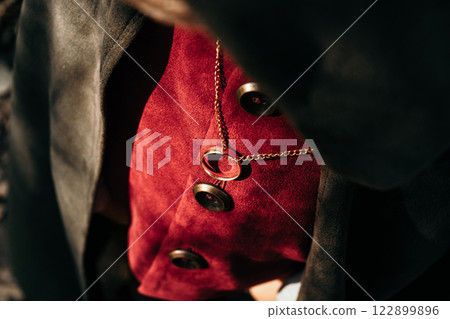 Little boy cosplayer in hobbit cape costume with golden ring pendant on chest. Fantasy journey Little boy cosplayer in hobbit cape costume with golden ring pendant on chest. Fantasy journey 122899896
