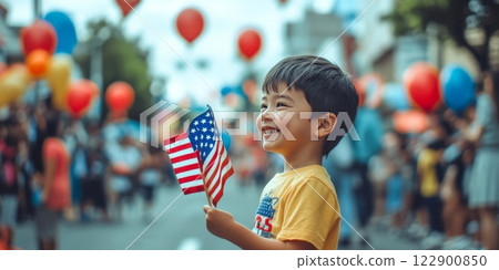 Young boy holding american flags and smiling at president's day parade 122900850