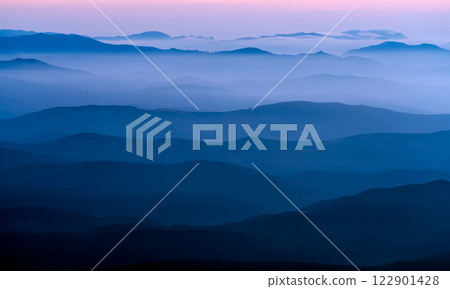 Pre-dawn twilight in the mountains, the crests of the mountains are divided into many planes by fog and morning light Pre-dawn twilight in the mountains, the crests of the mountains are divided into many planes by fog and morning light 122901428
