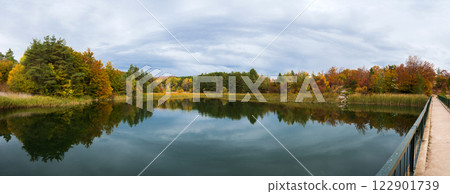 Panoramic view of peaceful and colorful autumn landscape with beautiful reflections in the lake. Panoramic view of peaceful and colorful autumn landscape with beautiful reflections in the lake. 122901739