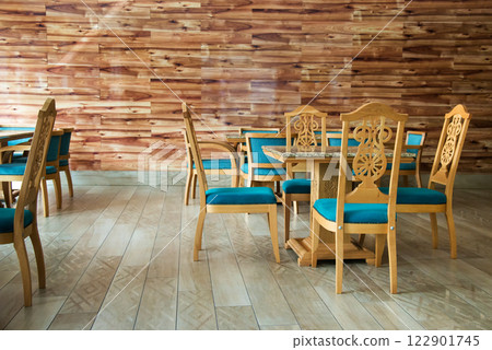 Restaurant interior with beautiful carved tables and chairs with blue fabric - selective focus Restaurant interior with beautiful carved tables and chairs with blue fabric - selective focus 122901745