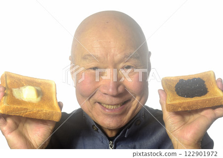 An elderly man eating toasted bread with a smile An elderly man eating toasted bread with a smile 122901972