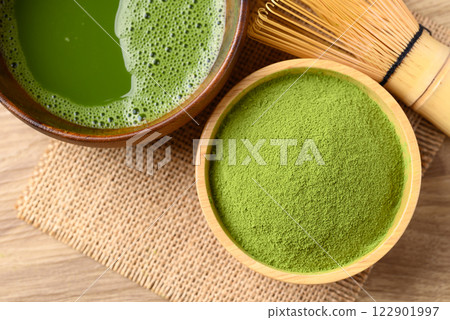 Matcha green tea powder and tea with chasen (bamboo whisk), Table top view 122901997