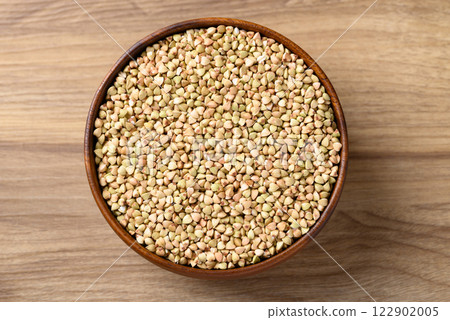 Organic buckwheat seed in bowl on wooden background, Food ingredient, Table top view 122902005