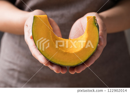 Section of green pumpkin holding by hand prepare for cooking Section of green pumpkin holding by hand prepare for cooking 122902014