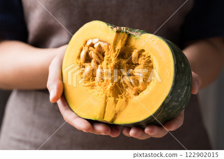 Half green pumpkin holding by hand prepare for cooking 122902015