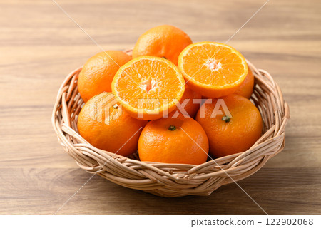 Mandarin tangerine orange fruit in basket on wooden background 122902068