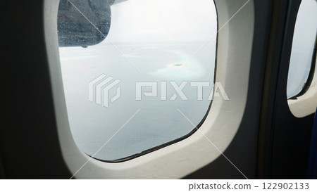 Tropical islands seen from airplane window flying over ocean 122902133