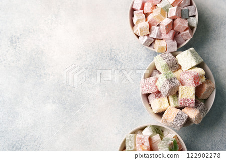Delicious assortment of colorful Turkish delight sweets displayed in three bowls on a neutral background Delicious assortment of colorful Turkish delight sweets displayed in three bowls on a neutral background 122902278