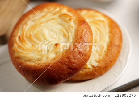Freshly baked cream cheese pastries on a delicate plate in a cozy bakery setting Freshly baked cream cheese pastries on a delicate plate in a cozy bakery setting 122902279