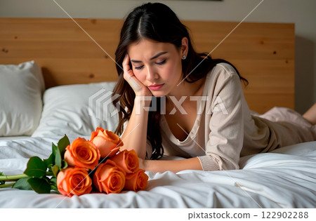 Sad woman lying on bed, she is not happy that she was given only flowers, bouquet of roses lying nearby. Disappointment with holiday. Sad Valentine's Day Sad woman lying on bed, she is not happy that she was given only flowers, bouquet of roses lying nearby. Disappointment with holiday. Sad Valentine's Day 122902288