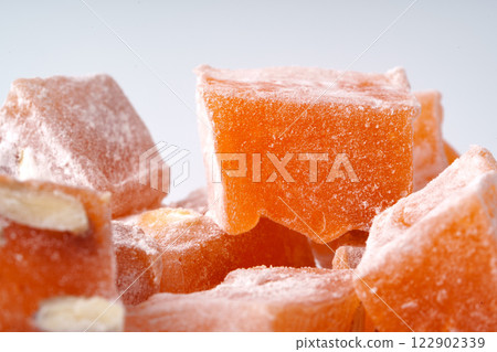 Orange Turkish delight pieces arranged on a light background highlighting the texture and sweetness of the dessert 122902339