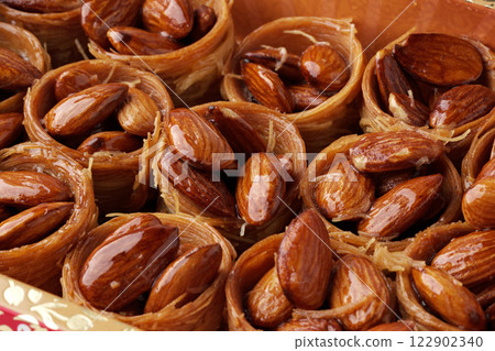 Delicious almond pastries filled with sweet syrup showcased in a traditional container at a market 122902340