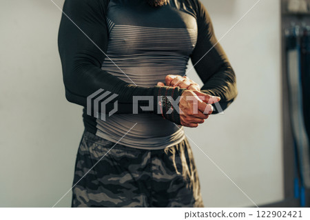Man preparing for weightlifting session in gym with focus on strength training and fitness Man preparing for weightlifting session in gym with focus on strength training and fitness 122902421