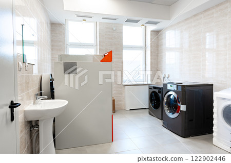 Laundry room featuring modern washer and dryer set in a bright, clean space with a white and gray color scheme Laundry room featuring modern washer and dryer set in a bright, clean space with a white and gray color scheme 122902446