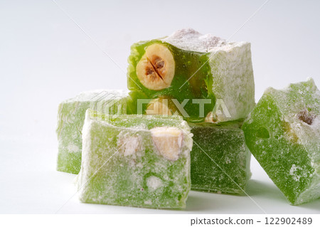 Delightful green Turkish delight with nuts arranged artistically on a clean background Delightful green Turkish delight with nuts arranged artistically on a clean background 122902489