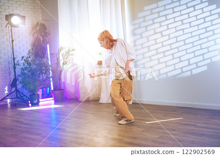 Dynamic dance performance highlighting expressive movement in a well-lit studio during an afternoon session 122902569