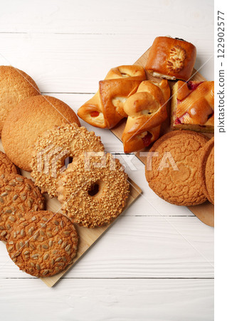Various types of baked cookies and pastries arranged on wooden platters for a delightful dessert display Various types of baked cookies and pastries arranged on wooden platters for a delightful dessert display 122902577