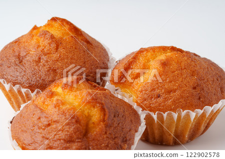Freshly baked muffins arranged on a white surface ready for serving during a morning gathering 122902578