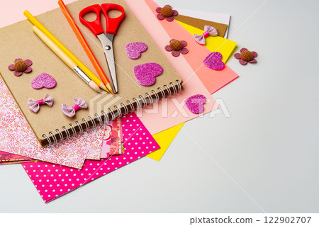 Crafting materials on a table showcasing colorful paper, scissors, and decorative embellishments for creative projects 122902707