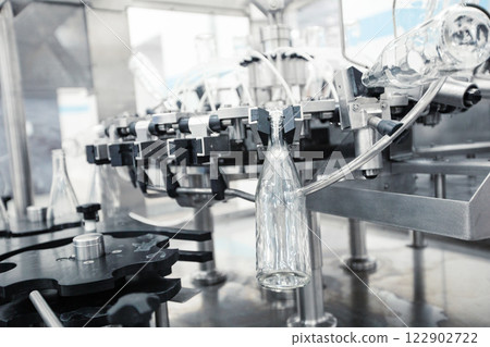 Modern beverage bottling line with glass containers in a production facility Modern beverage bottling line with glass containers in a production facility 122902722