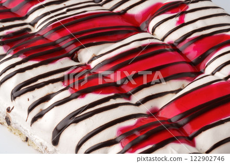 Delicious dessert featuring layers of cream, chocolate, and cherry sauce at a bakery 122902746