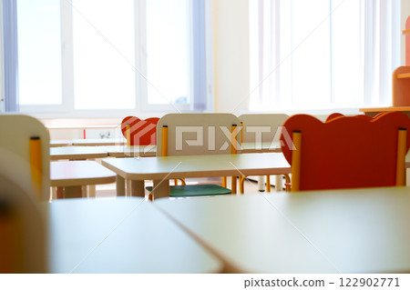 Bright classroom with empty desks and colorful chairs ready for students in a learning environment Bright classroom with empty desks and colorful chairs ready for students in a learning environment 122902771