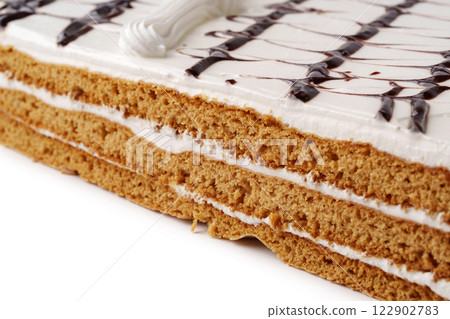 Layers of sweet dessert with creamy frosting and decorative chocolate drizzle on top Layers of sweet dessert with creamy frosting and decorative chocolate drizzle on top 122902783