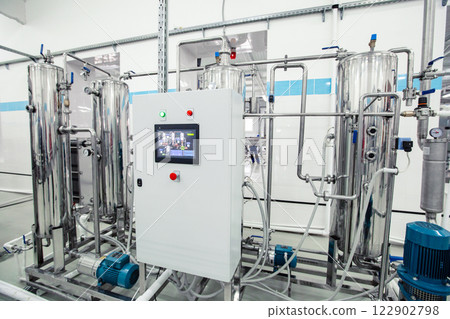 Modern industrial machinery in a clean facility for processing and manufacturing products in an advanced factory setting Modern industrial machinery in a clean facility for processing and manufacturing products in an advanced factory setting 122902798