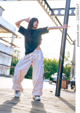 Dancer showcases urban choreography in sunlight near construction site with modern architecture 122902827