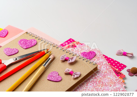 Crafting project with decorative supplies on a table featuring scissors, pencils, and colorful paper 122902877