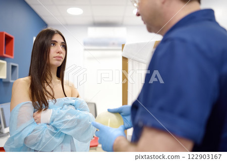 Doctor mammologist examines woman breasts. Correcting the shape of the breast - lift, reduction, reconstruction, augmentation. 122903167