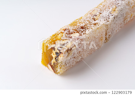 Traditional nougat with nuts and honey displayed on a clean white background highlighting its texture and ingredients Traditional nougat with nuts and honey displayed on a clean white background highlighting its texture and ingredients 122903179